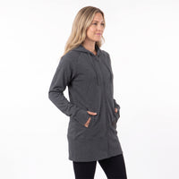 A woman modeling a dark gray zip-up hoodie with a drawstring hood and front pockets, paired with black leggings, against a plain white studio background.