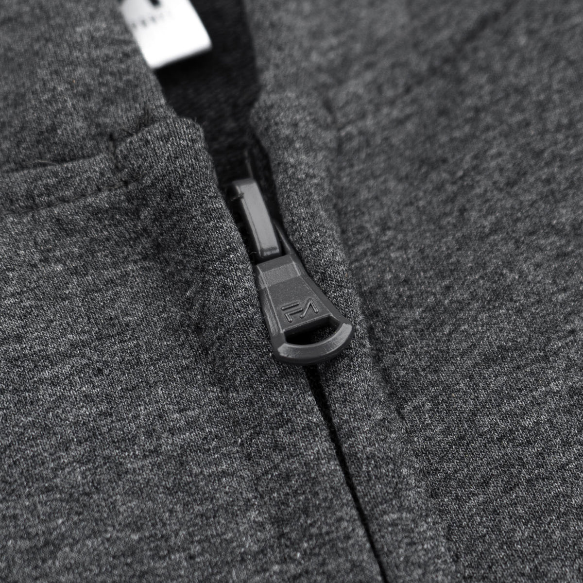 Close-up of a dark gray heather zippered garment with a black zipper pull and a white fabric tag visible near the collar.