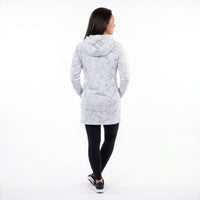 A woman is shown from behind wearing a light gray hooded jacket with a darker gray abstract pattern, paired with black leggings and black sneakers, against a solid white background.