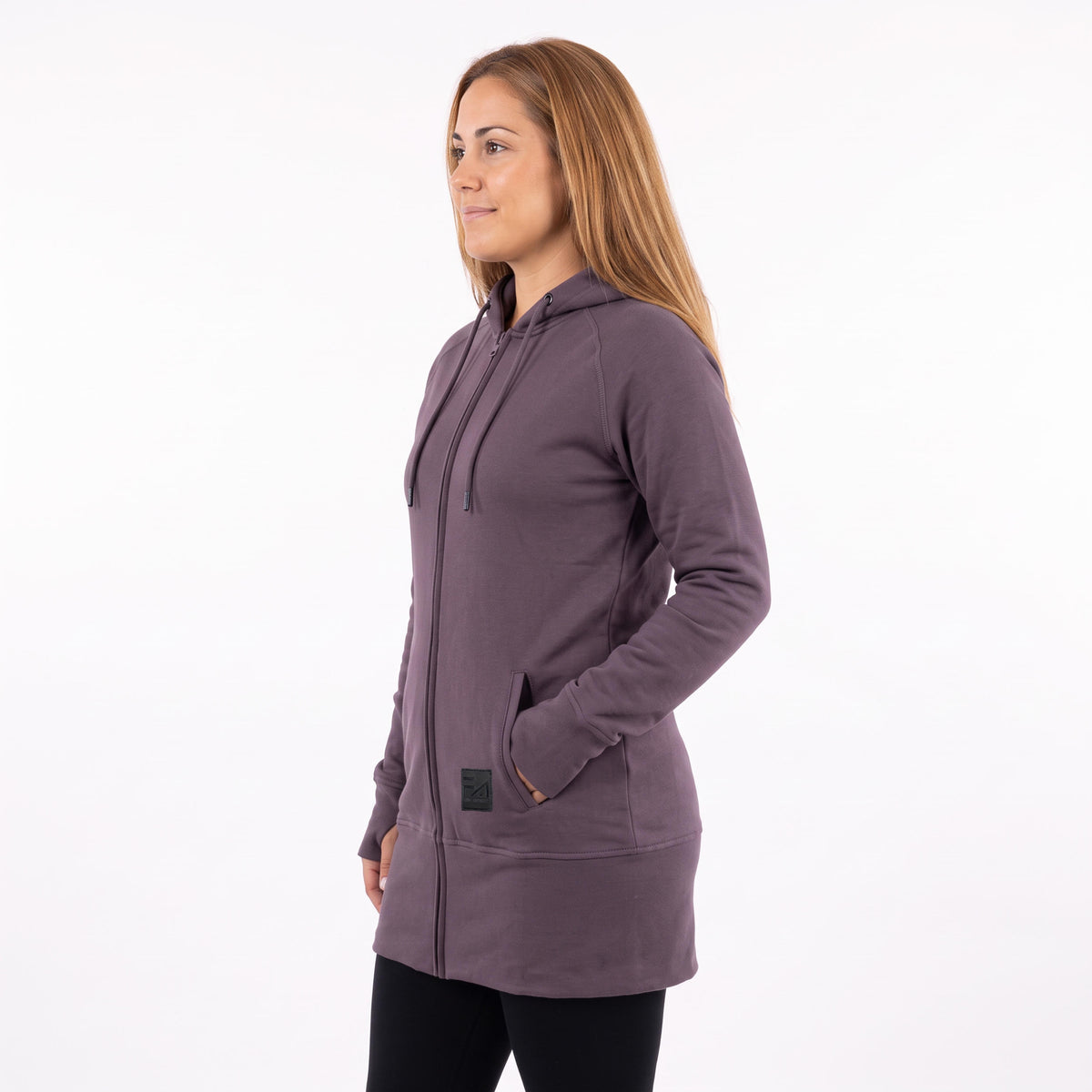 A woman wearing a dusty purple full-zip hooded sweatshirt, shown from a side profile against a plain white background.