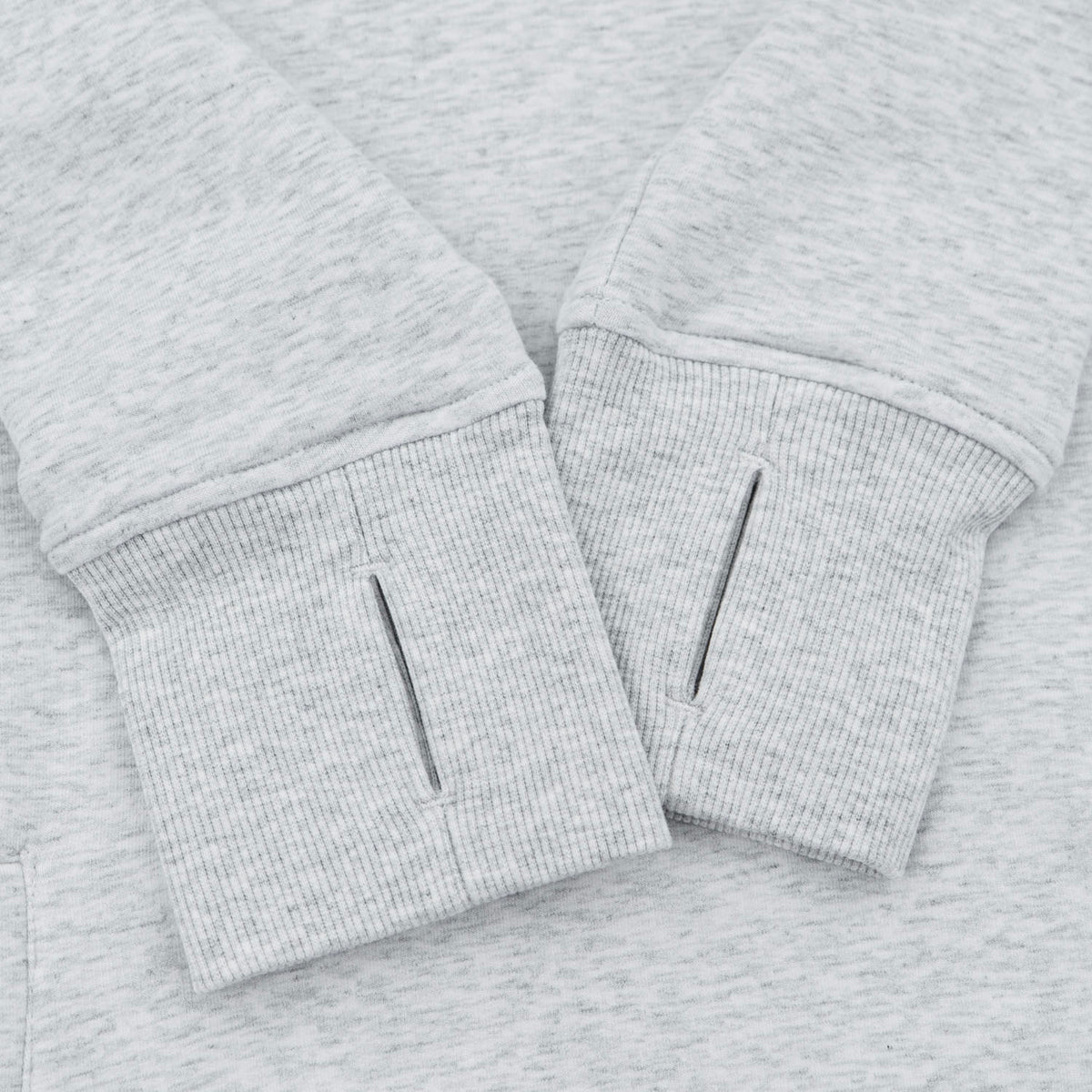 Close-up of a light heather gray sweatshirt cuff with a vertical slit detail on the front.