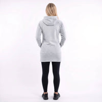A woman viewed from behind wearing a light gray hooded sweatshirt, black leggings, and black shoes against a plain white studio background.